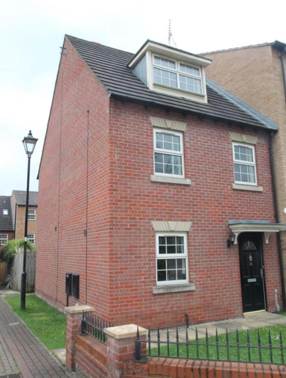 a red brick house with a black roof at Main House in Rotherham