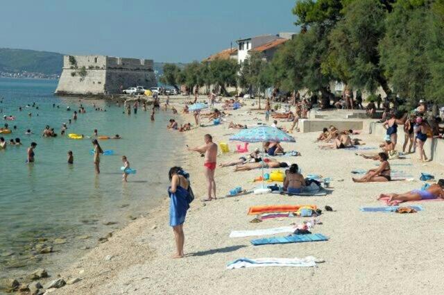 a group of people on a beach in the water at Apartman Lavanda in Kaštela
