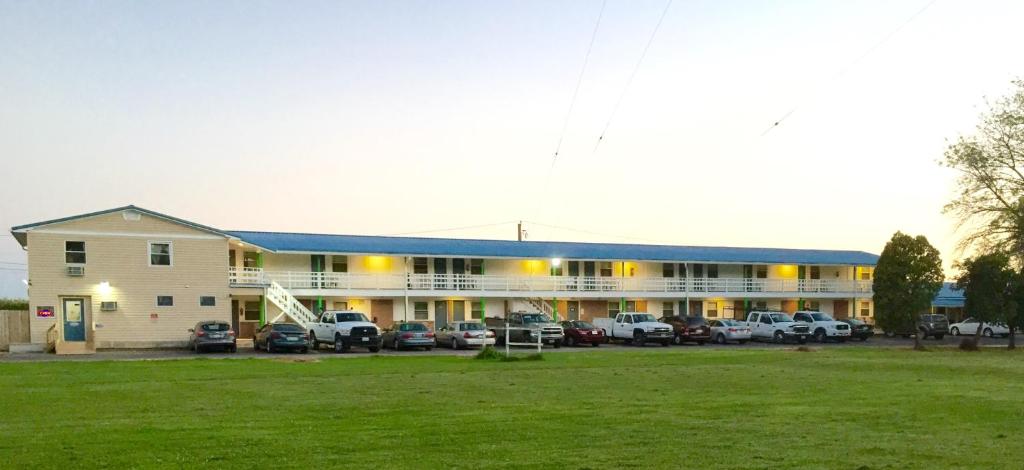 a large building with cars parked in a parking lot at Relax Inn in Streator