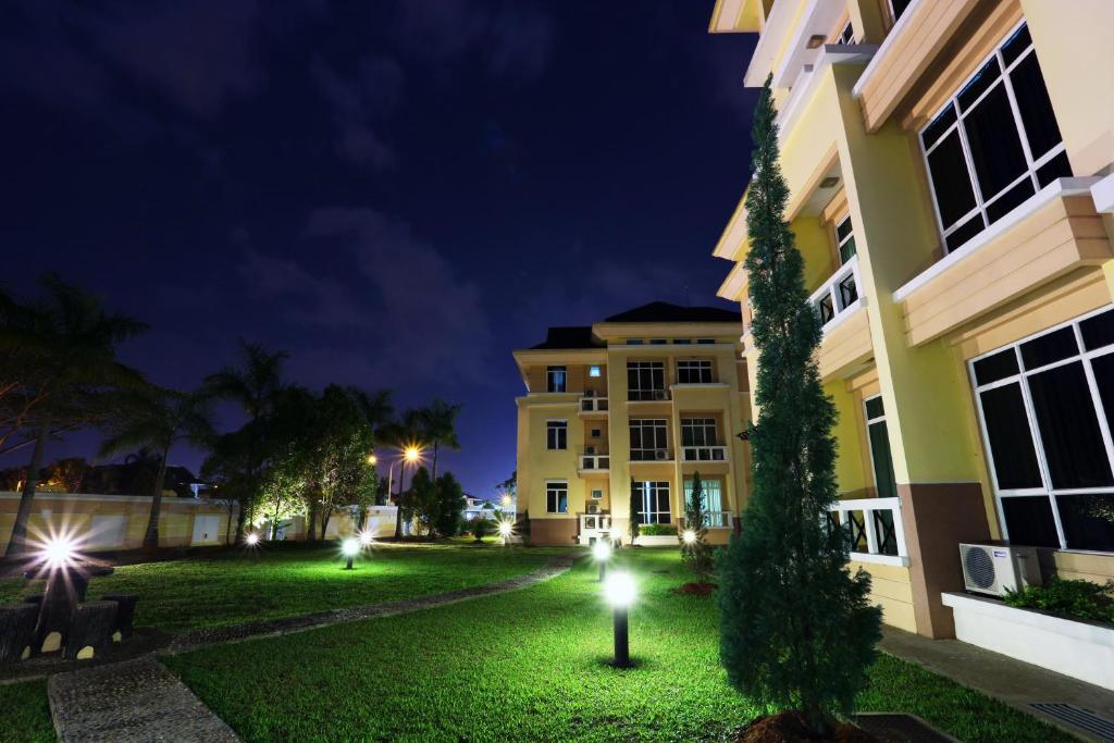 a building at night with a tree in the yard at Song Service Apartment formerly known as Jinhold Service Apartment in Kuching