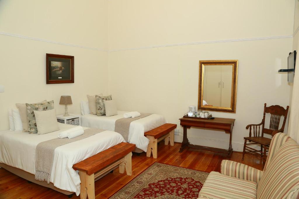 a room with two beds and a mirror at Die Hoekhuis in Cradock