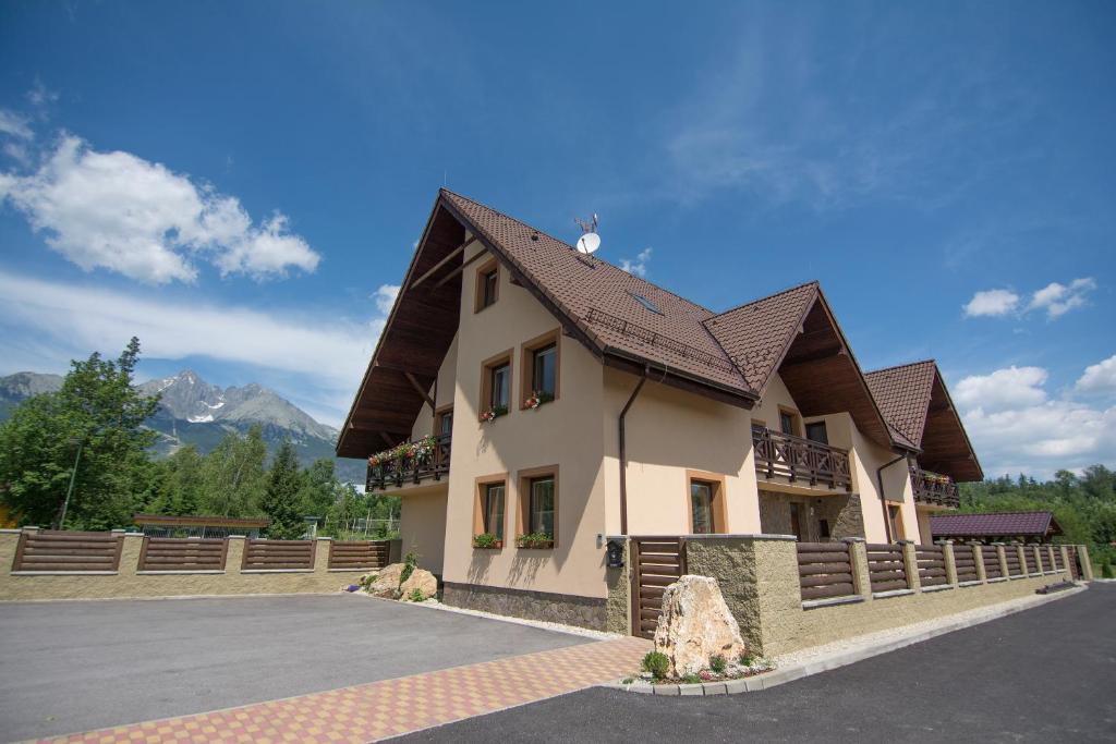 a large building with a brown roof at Vila Kamah in Vysoke Tatry - Tatranska Lomnica.