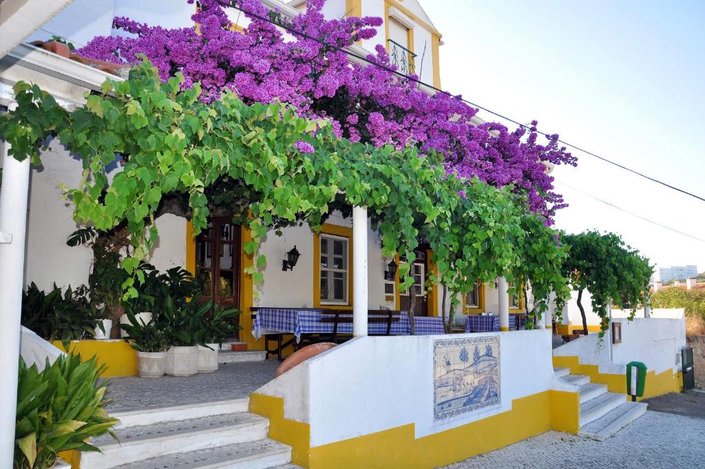 un edificio con flores púrpuras a su lado en Sleep In Bucelas en Bucelas