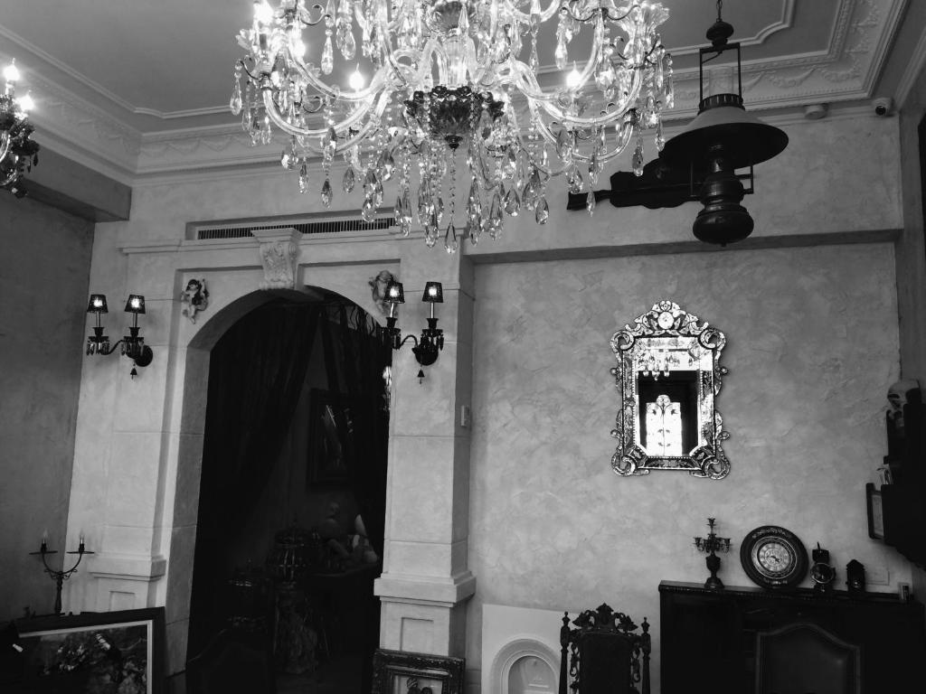 une photo en noir et blanc d'une chambre avec un lustre dans l'établissement Angel Wings Inn, à Hualien