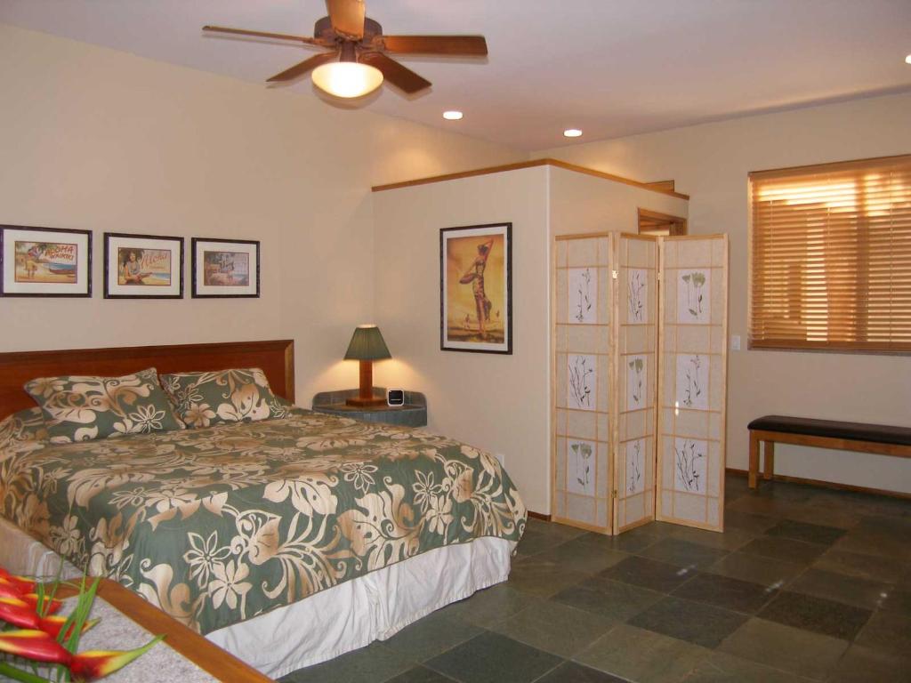 una camera con letto e ventilatore a soffitto di Aloha AKU - Bamboo 1 a Kihei