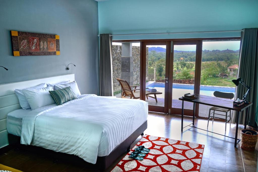 a bedroom with a bed and a view of a pool at Borobudurhills in Borobudur
