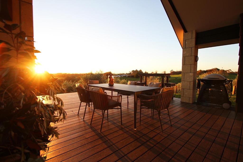 a patio with a table and chairs on a deck at Ohaupo Olives in Ohaupo