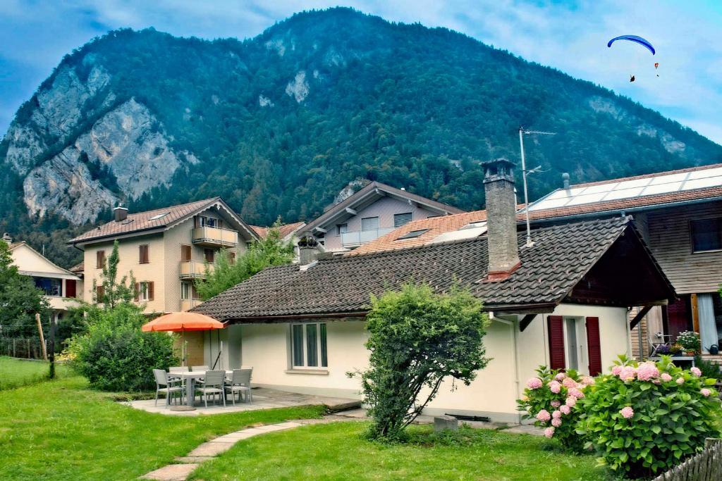 ein Haus in einem Dorf mit einem Berg im Hintergrund in der Unterkunft Beausite Apartments in Interlaken