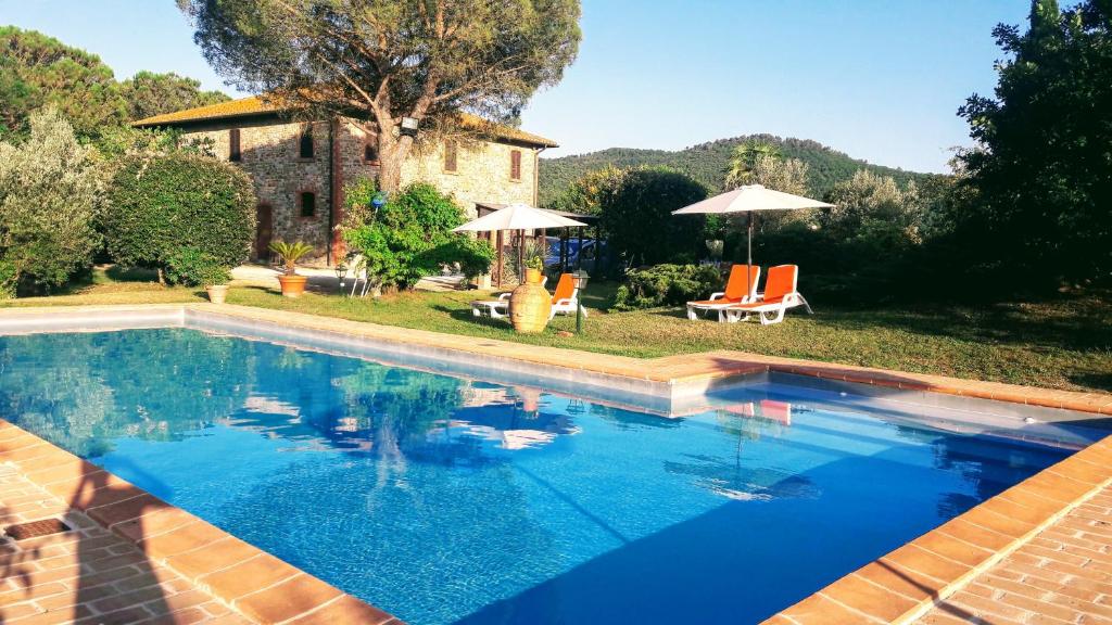 a swimming pool with chairs and umbrellas in a yard at Private pool Villa Wine&cooking -Trasimeno Lake in Panicale