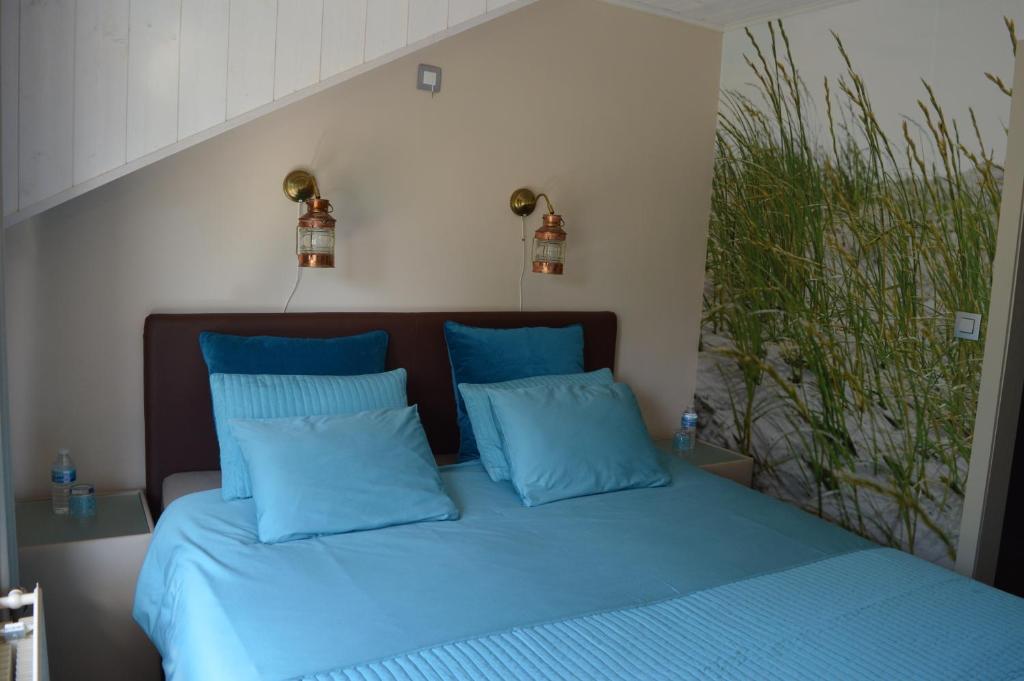 a bedroom with a blue bed with blue pillows at B&B Bij MoeMee in Ghent