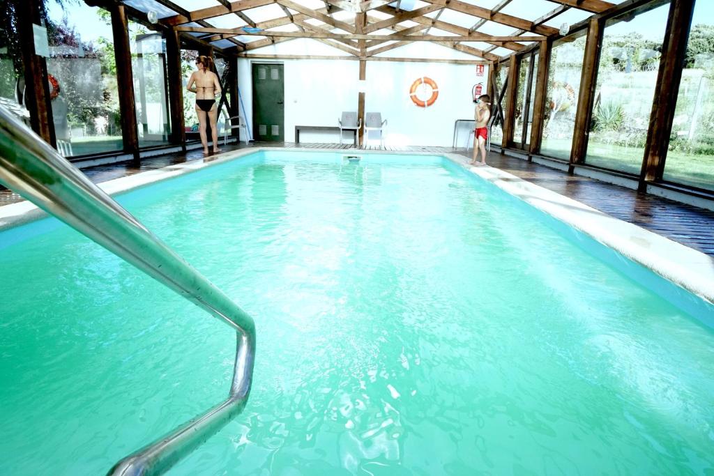 una piscina de agua azul en un edificio en Hotel Rural La Peregrina, en Carucedo