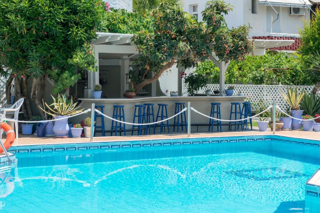 - une piscine dans une cour ornée d'arbres et de plantes dans l'établissement Hotel George, à Thasos