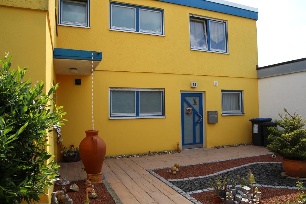 a yellow house with a blue door at Apartment Grunbach in Remshalden