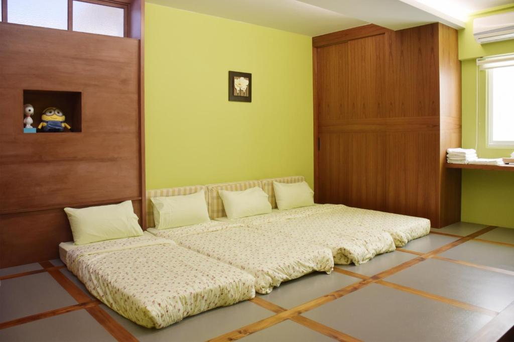a large bed in a room with a wooden door at Red Roof B&B in Taitung City
