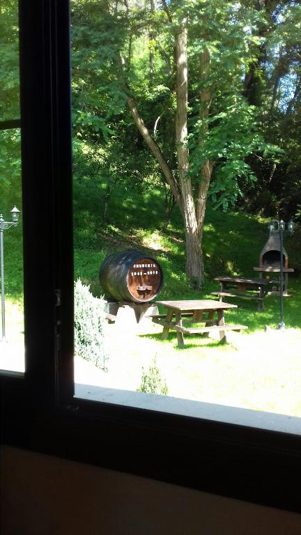 a window view of a park with a picnic table and a barrel at Apartamentos Rurales Les Mestes in Tazones