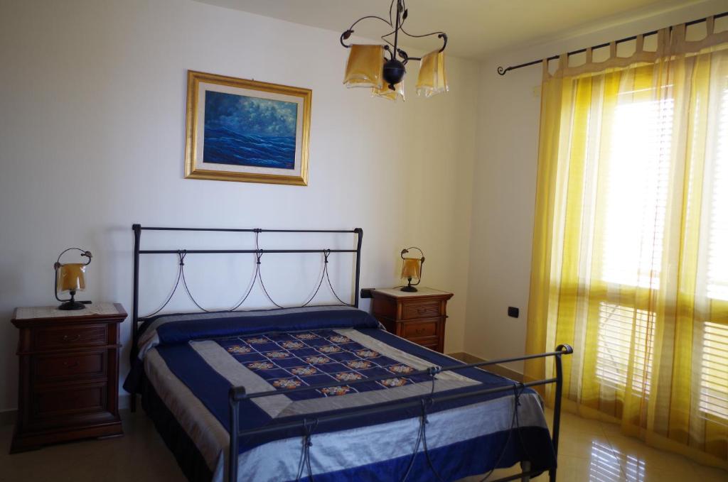 um quarto com uma cama e uma janela em B&B La Pineta em SantʼAntìoco