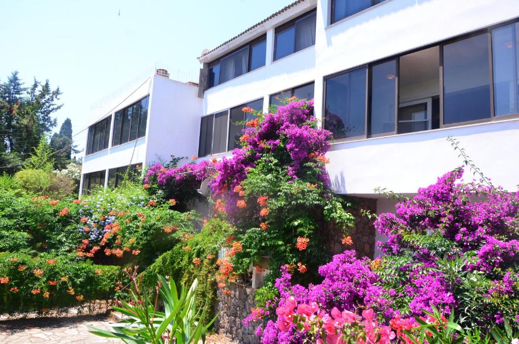 een gebouw met een bos bloemen ervoor bij Kommeno Linga Longa Apartments with sea view and beach in Kommeno