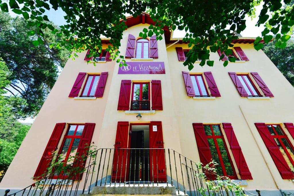 a building with red doors and windows at Le Vizzavona in Vizzavona