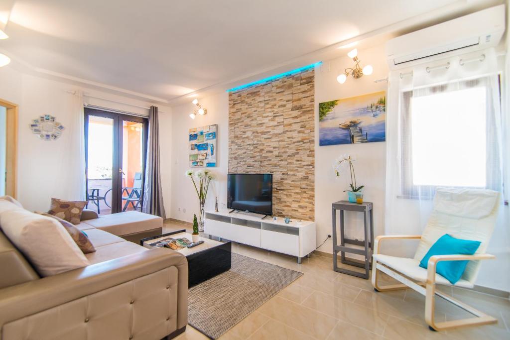 a living room with a couch and a tv at Charming house on the beach and Deluxe Apartment in Pula