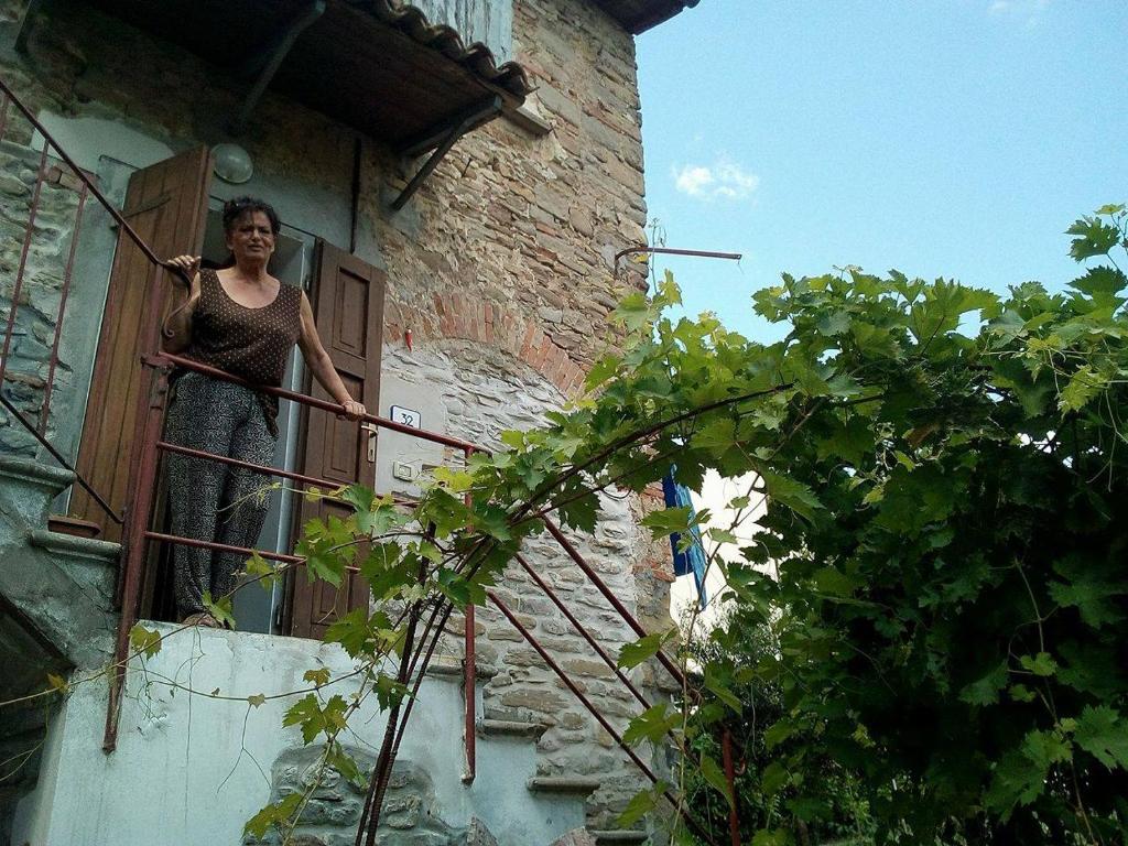 ブリジゲッラにあるB&B Il Conventinoの建物のバルコニーに立つ女性