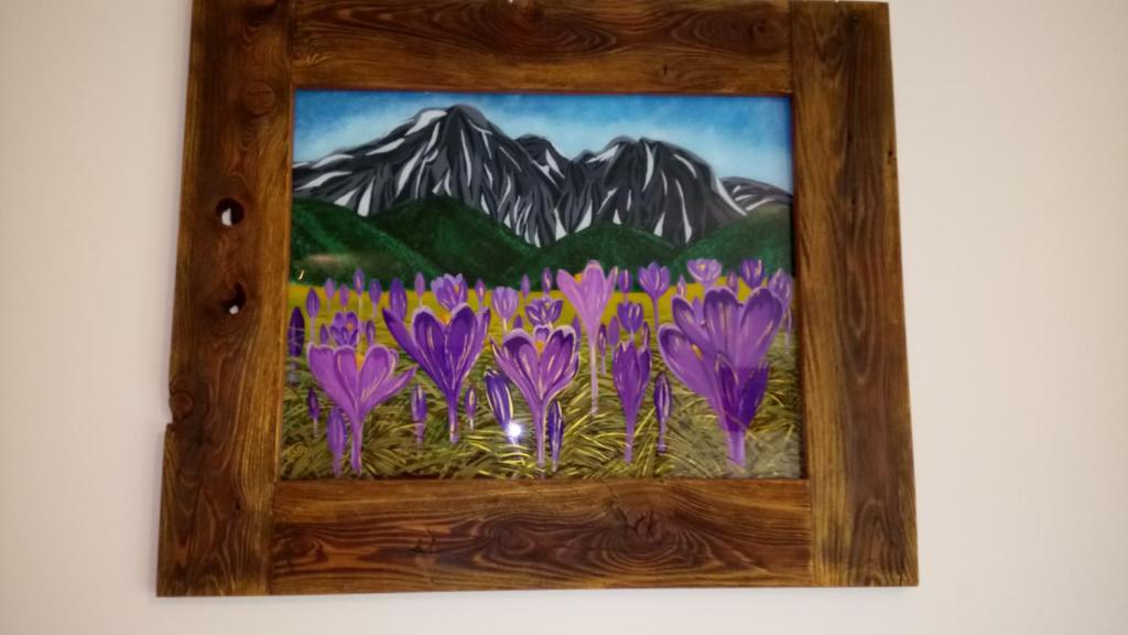 een schilderij van paarse bloemen voor een berg bij Apartament Krokus SPA in Kościelisko