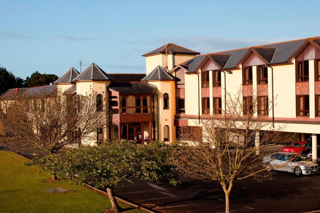 a large building with a car parked in a parking lot at Gold Coast Resort Dungarvan in Dungarvan