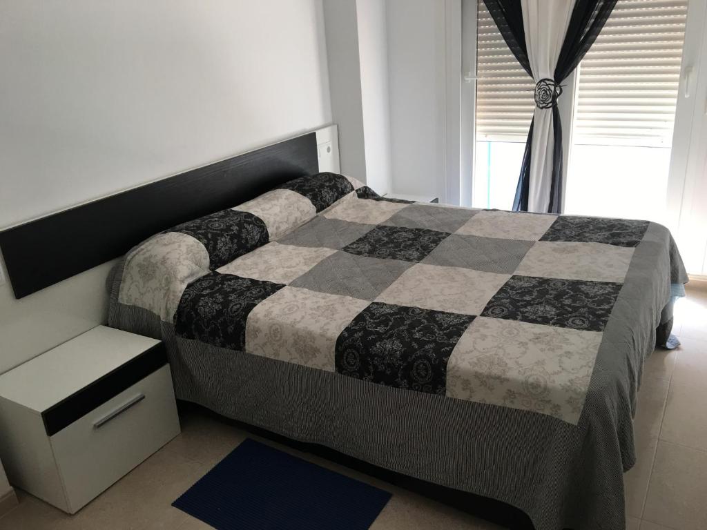 ベニカルロにあるApartamento en Benicarloのベッドルーム(白黒のベッド1台、窓付)
