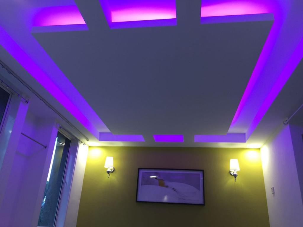 um quarto com luzes roxas no tecto em 7 Star Hotel em Kota Damansara