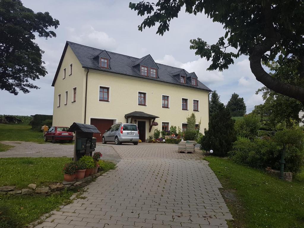 duży dom z samochodem zaparkowanym przed nim w obiekcie Strasse des Friedens w mieście Hilmersdorf
