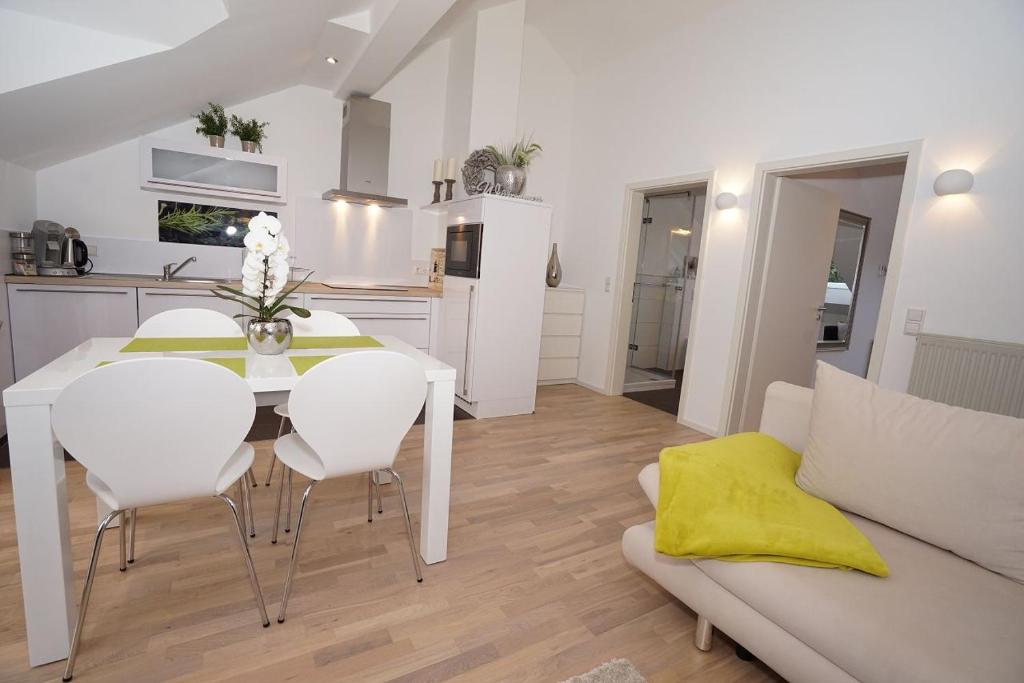 cocina y sala de estar con mesa blanca y sillas en York Cottage en Traben-Trarbach