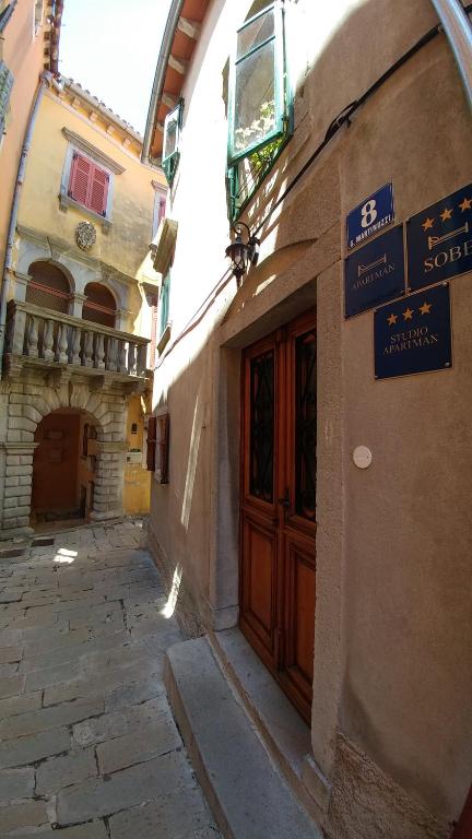 Une allée avec un bâtiment doté d'une porte en bois dans l'établissement Guesthouse Boris, à Labin