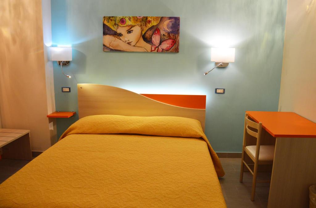 クロトーネにあるGood Night Moon B&Bのベッドルーム1室(ベッド1台付)が備わります。壁には絵画が飾られています。