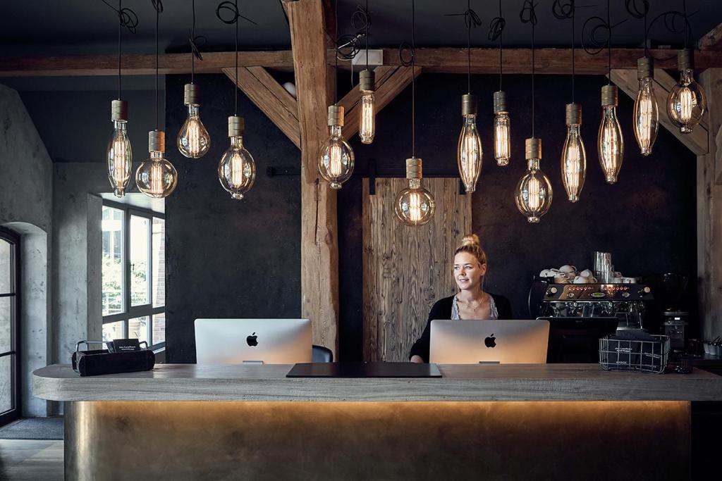 une femme assise à une table avec deux ordinateurs portables dans l'établissement Landhaus Flottbek Boutique Hotel, à Hambourg