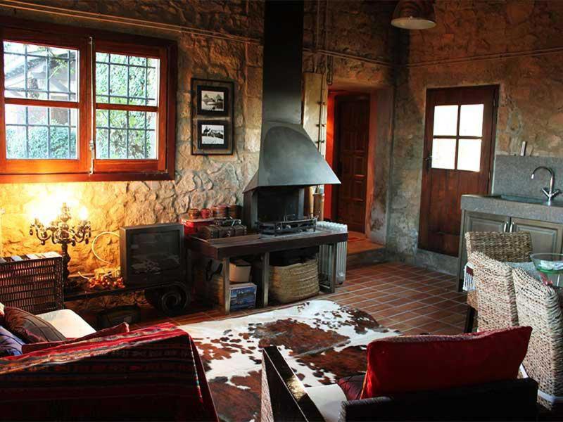 sala de estar con chimenea y sofá en Pla de Moixons, en Oristà