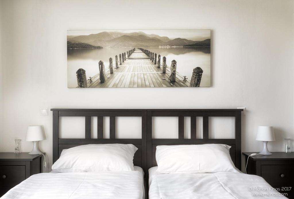 a bedroom with two beds and a bridge over a lake at Garni HOTEL Fellini in Žiar nad Hronom