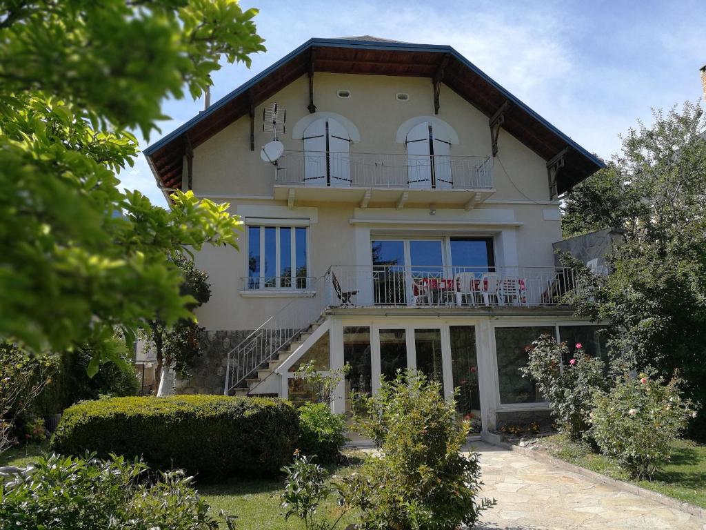 Casa blanca grande con ventanas y balcón en Villa Le Gai Soleil, en Embrun