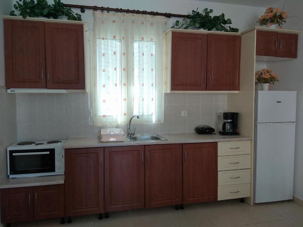 a kitchen with wooden cabinets and a sink and a microwave at Eirini- Ioanna in Sami