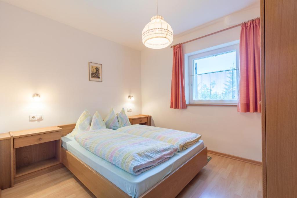 sypialnia z łóżkiem i oknem w obiekcie Appartements Haus Pichler w mieście Eggen