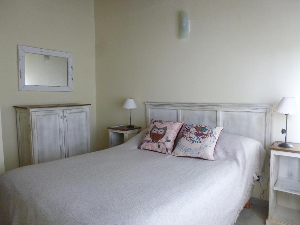 a bedroom with a white bed with two pillows at Arroyo Departamentos in Tandil