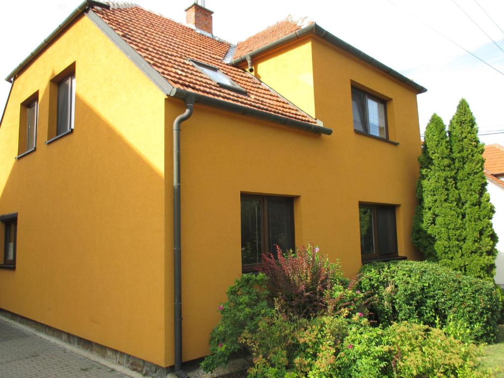 żółty dom z czerwonym dachem w obiekcie RD Černčín Bučovice w mieście Černčín