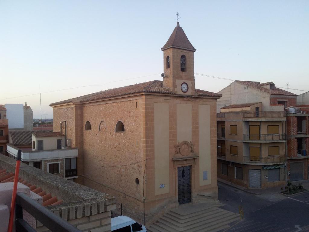 ein Gebäude mit einem Uhrturm darüber in der Unterkunft Hostal Central in Fuente-Álamo