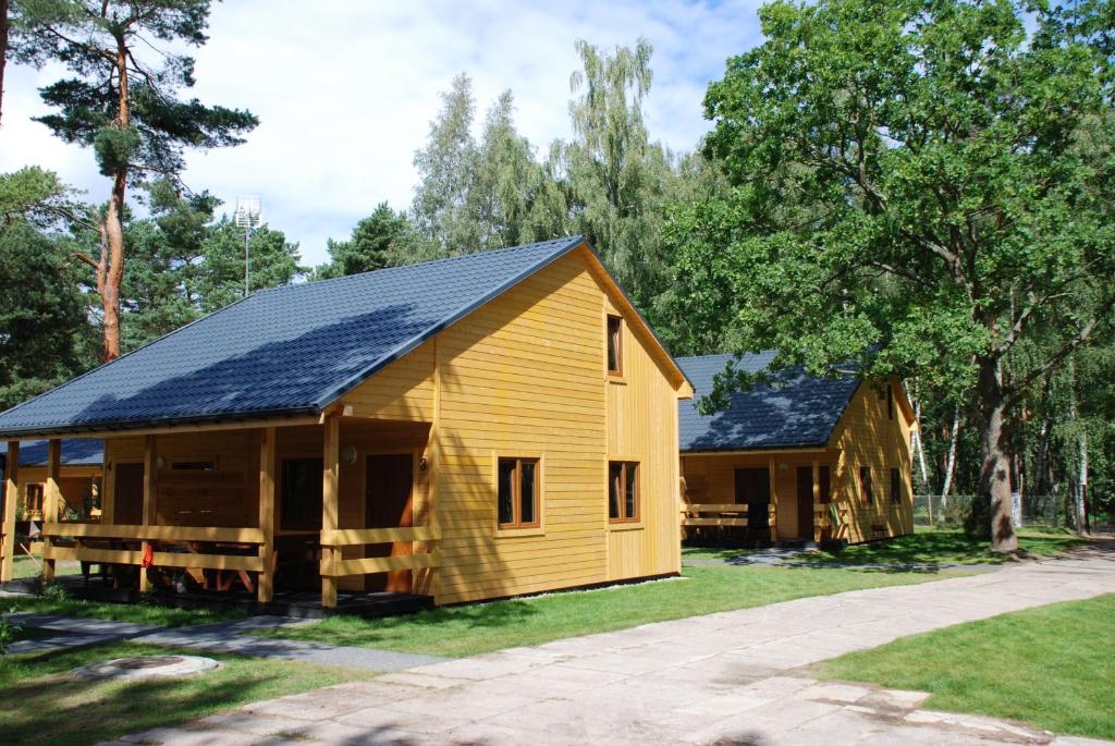 uma casa de madeira com painéis solares em AURUM Domki Letniskowe em Pogorzelica