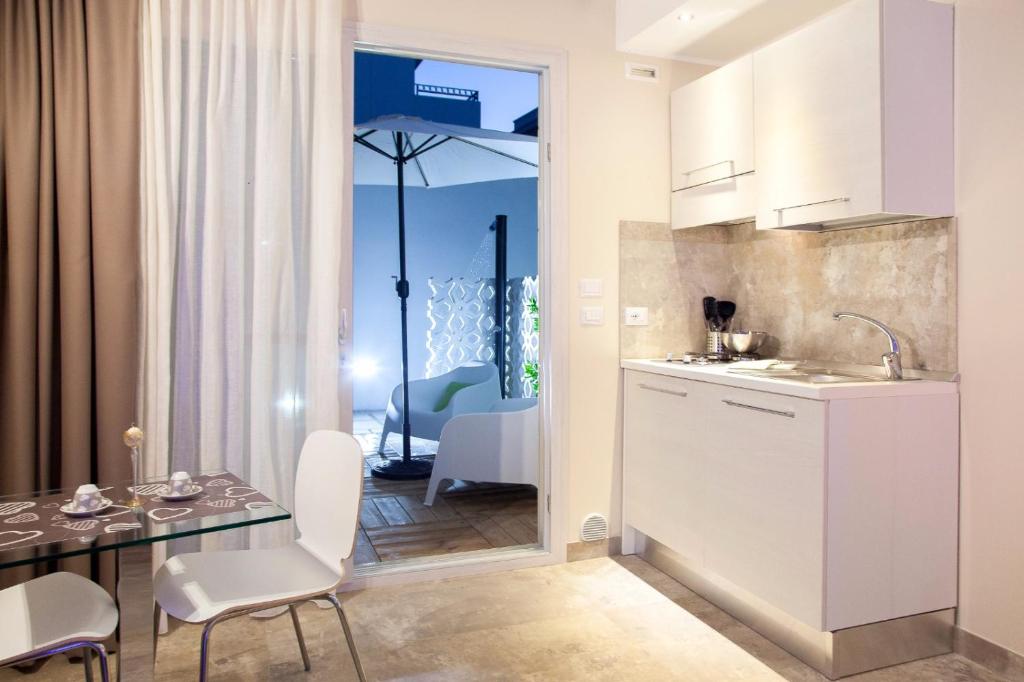 a kitchen and dining room with a table and chairs at Le Sinfonie Rooms in Porto Cesareo