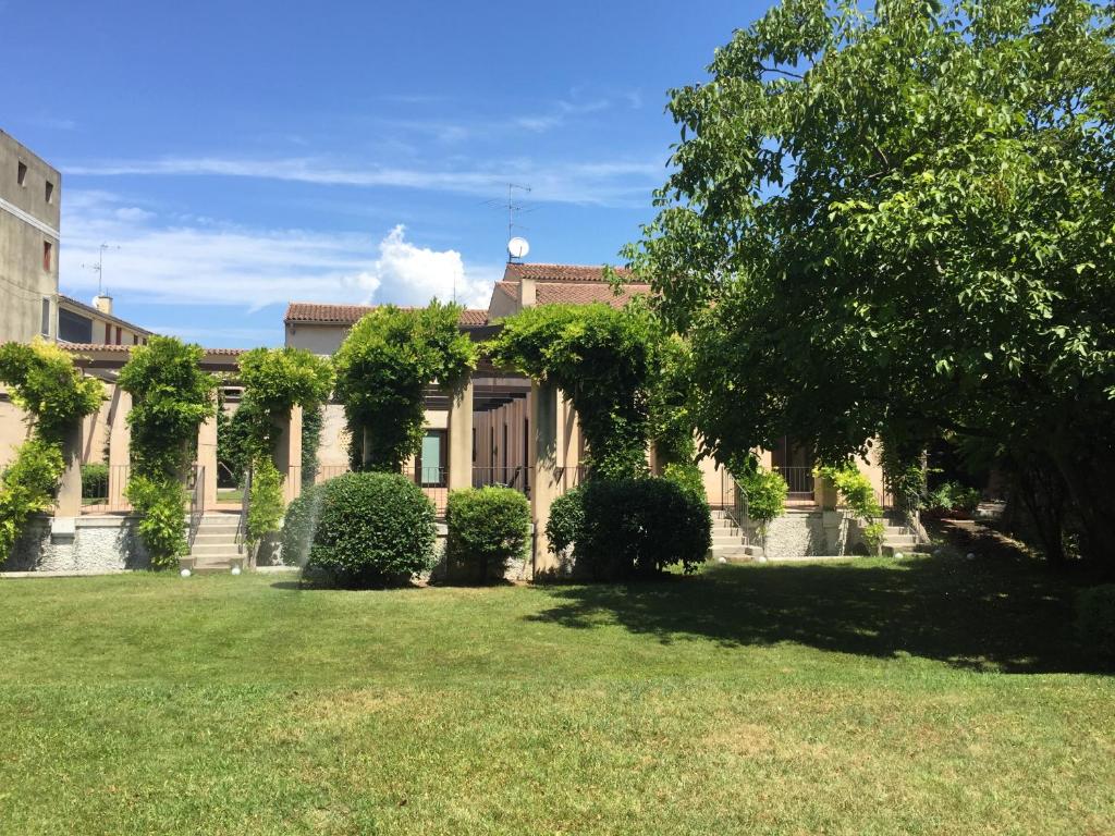 a building with ivy on the side of a yard at Ca'Bert Villa dei Glicini in Castelnuovo del Garda