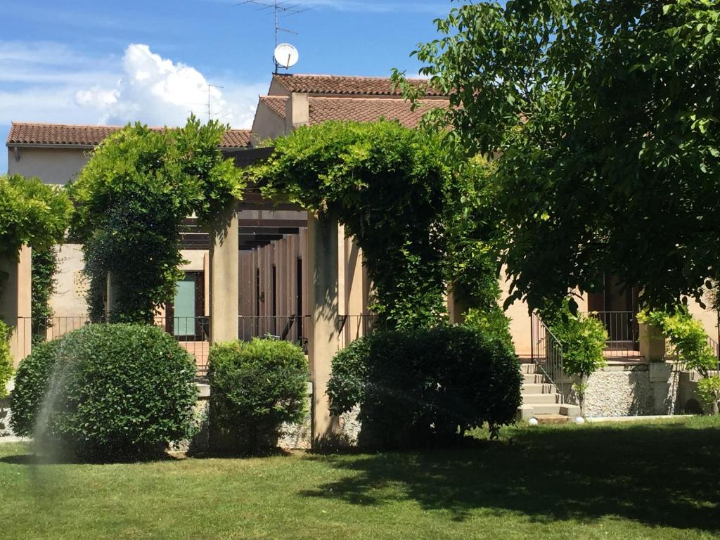 a house with bushes in front of a yard at Ca' Bert Villa dei Glicini B&B in Castelnuovo del Garda