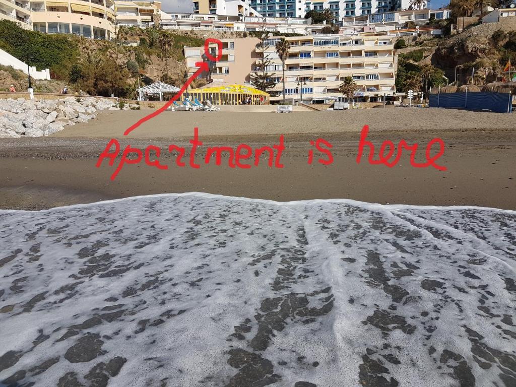 a sign that says experiment is hot on a beach at Roca Chica Torremolinos in Torremolinos