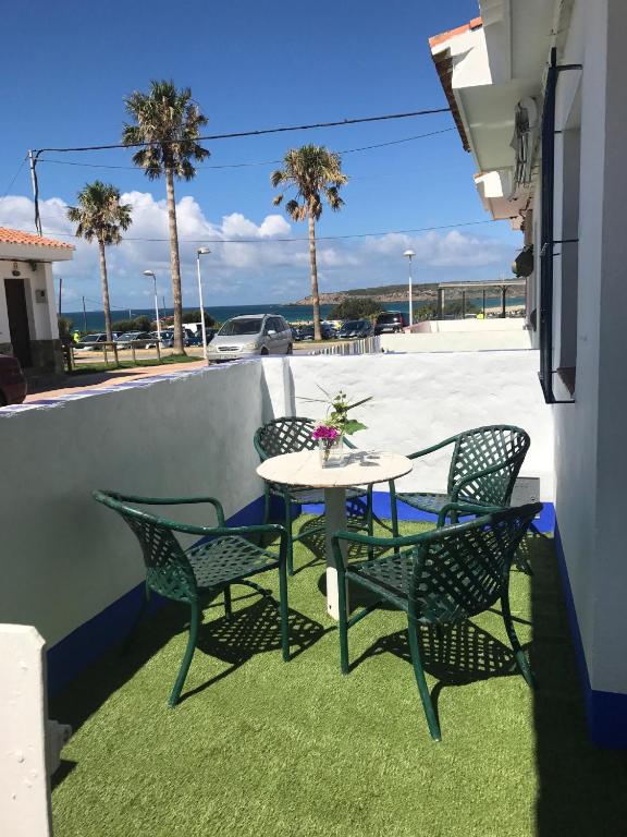 a table and chairs on a patio with palm trees at Casa Azul in Bolonia