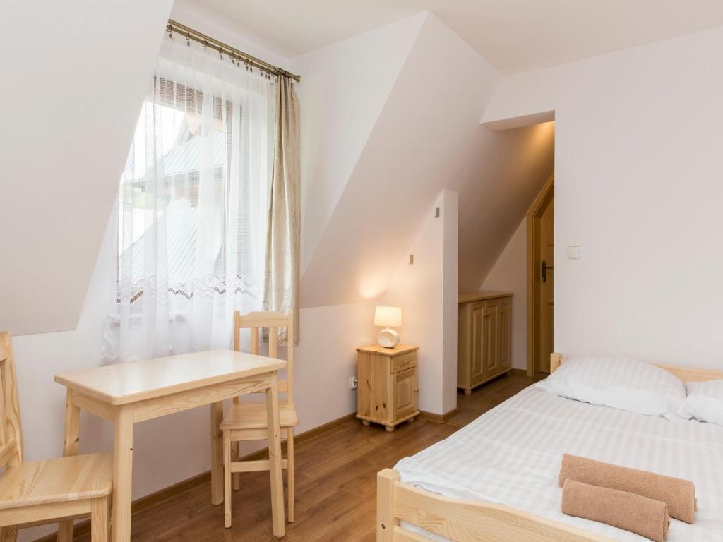 ザコパネにあるPokoje Gościnne Bachledzki Wierchのベッドルーム1室(ベッド1台、デスク、窓付)