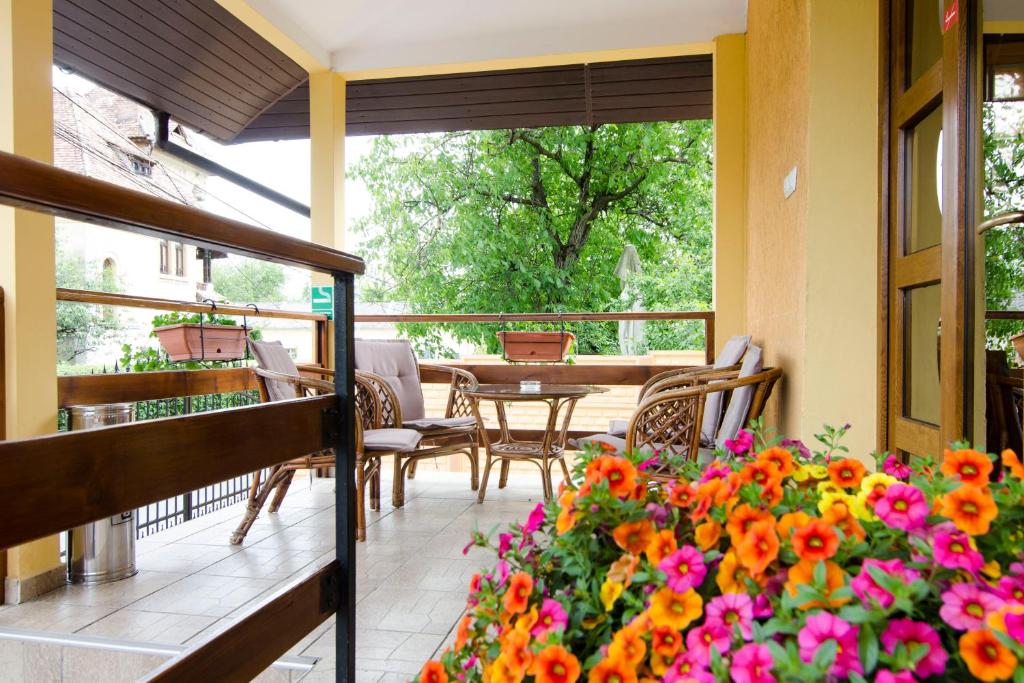 balcón con mesa, sillas y flores en Pension Alexia, en Sibiu
