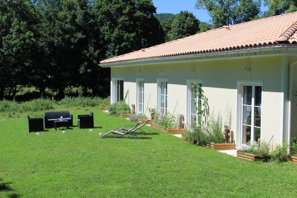 una casa con un patio de césped al lado de un edificio en Du Coté de Lacoume, en Anla